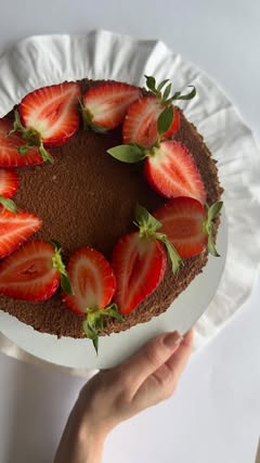 Čoko-tiramisu medovik posut kakaom i ukrašen svežim jagodama
